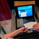 A polling judge, right, helps guide a voter's ballot into a voting machine during the Pennsylvania primary election, at Mont Alto United Methodist Church in Alto, Pa., on May 17, 2022.