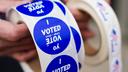 A poll worker holds voting stickers for community members Nov. 7, 2023, at Central Elementary School in Allentown, Lehigh County, Pennsylvania.
