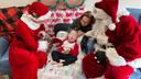 Santa and Mrs. Claus sit with a child and his mother at the Children's Home of Pittsburgh.