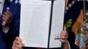 President Donald Trump holds a signed executive order on permitting for data center infrastructure.