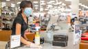 Esther Iglesias, a sales clerk in the shoe department at Boscov's at Plymouth Meeting Mall, wipes a counter.