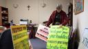 Sister Anne McCarthy with the Benedictine Sisters of Erie looks through her signs protesting President Donald Trump’s nationwide immigration crackdown.
