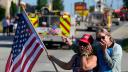 Merri Cambo of Saxonburg, Pa., and her friend, Jane Wesolosky, of Buffalo, Pa., react as the funeral procession for Corey Comperatore passes by July 19 in Sarver, Pennsylvania.