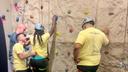 Campers prepare to mount a rock climbing wall.