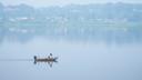 People fish on the Susquehanna River amidst haze from Canadian wildfires, June 29, 2023, in Harrisburg, Pa.