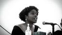 Jazmin Evans, a Philadelphia-based health advocate, speaks into a microphone.