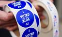 A poll worker holds voting stickers for community members Nov. 7, 2023, at Central Elementary School in Allentown, Lehigh County, Pennsylvania.