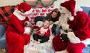 Santa and Mrs. Claus sit with a child and his mother at the Children's Home of Pittsburgh.