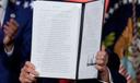 President Donald Trump holds a signed executive order on permitting for data center infrastructure.