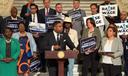Rep. Jason Dawkins (center) speaks at a new conference urging the PA Senate to raise the minimum wage.