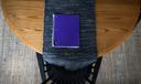 A purple notebook on a dining room table.