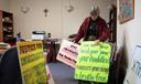 Sister Anne McCarthy with the Benedictine Sisters of Erie looks through her signs protesting President Donald Trump’s nationwide immigration crackdown.