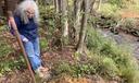 Bradford resident and retiree Barbara Laxon stands next to an abandoned, uncapped oil well.