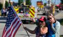 Merri Cambo of Saxonburg, Pa., and her friend, Jane Wesolosky, of Buffalo, Pa., react as the funeral procession for Corey Comperatore passes by July 19 in Sarver, Pennsylvania.