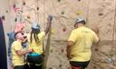 Campers prepare to mount a rock climbing wall.