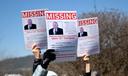 People hold up signs of U.S. Rep. Glenn Thompson that say “missing” during a protest outside his Bellefonte office.