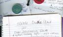 A photo of a notebook, paper, a cross, and sobriety chips.