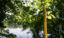 A pipeline marker along a riverbank.