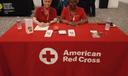 Red Cross volunteer Mary Harper (right) sits at a table