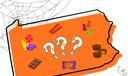 A Halloween-themed illustration of Pennsylvania featuring candies, cobwebs, skeletons, and a black cat.