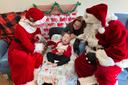 Santa and Mrs. Claus sit with a child and his mother at the Children's Home of Pittsburgh.