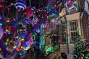 Rowhomes and trees are decked out in holiday lights and ornaments on this stretch of South 13th Street in Philadelphia.