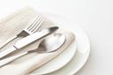 A stock image of a plate, silverware, and napkin.