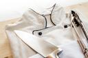 A stock image of a chef's coat and tongs on a wooden board. A stock image of a chef's coat and tongs on a wooden board.