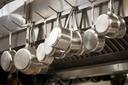 A stock image of pans hanging in a restaurant.