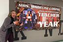 Madeline Loring poses with a sign celebrating her Teacher of The Year Award.