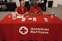 Red Cross volunteer Mary Harper (right) sits at a table