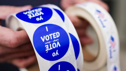 A poll worker holds voting stickers on Nov. 7, 2023.