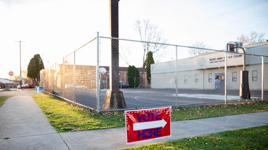 A “vote here” sign outside a polling place. A “vote here” sign outside a polling place.
