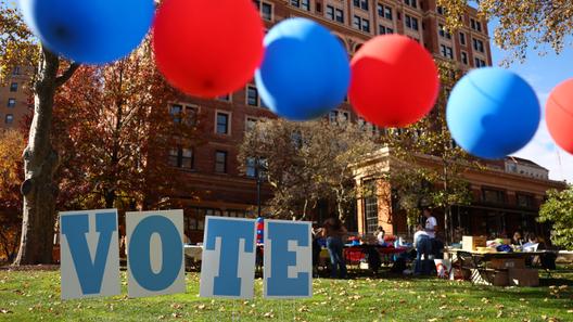 Students on the campus of the University of Pittsburgh walk past a ‘vote’ sign on Election Day, Nov. 5., 2024.