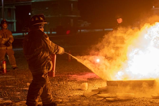 A firefighter puts out a fire during a training class.