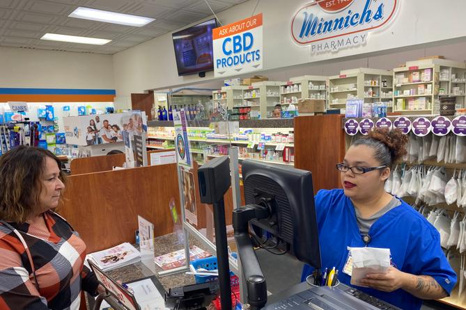 Customer Lisa Durs is helped by pharmacy clerk Kira Tomoney at Minnich's Pharmacy in York County.