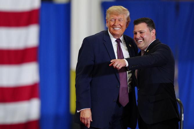 President Donald Trump and Rep. Ryan Mackenzie, R-Pa., right, appear on stage together during an event at a Mack Trucks facility, Tuesday, June 23, 2026, in Macungie, Pa.