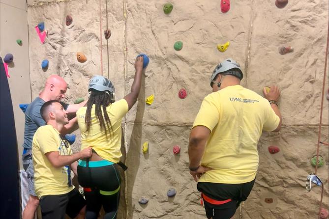 Campers prepare to mount a rock climbing wall.