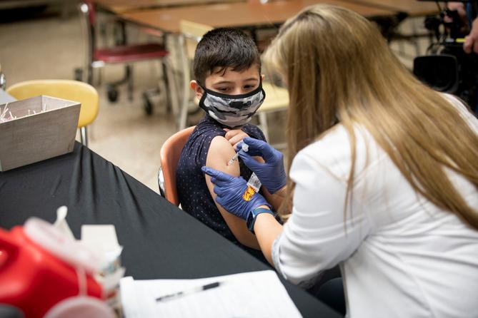 A child receives a vaccine from a nurse.