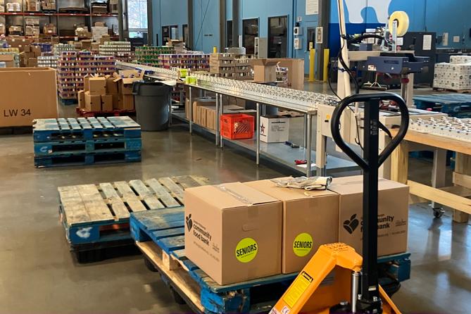 The senior food box assembly line at the Greater Pittsburgh Community Food Bank. Each package receives a package which includes canned fruits, vegetables, and beans, pasta, cereal, juice, and cheese.