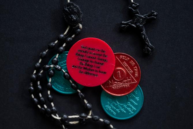 A photo of a rosary and sobriety chips. A photo of a rosary and sobriety chips.