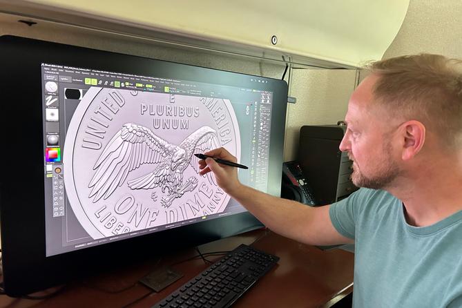 Medallic artist Eric David Custer at his workstation, showing his design for the tails side of the semiquincentennial dime on a computer screen.