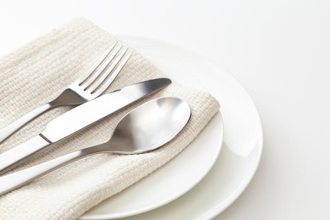 A stock image of a plate, silverware, and napkin.