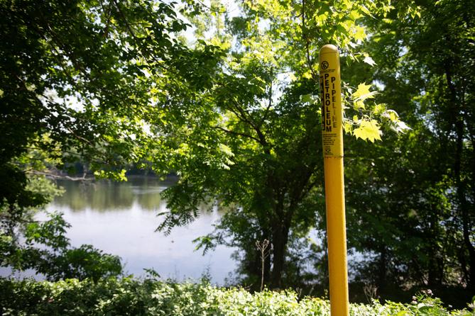 A pipeline marker along a riverbank.