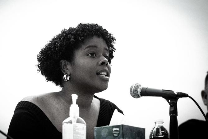 Jazmin Evans, a Philadelphia-based health advocate, speaks into a microphone.