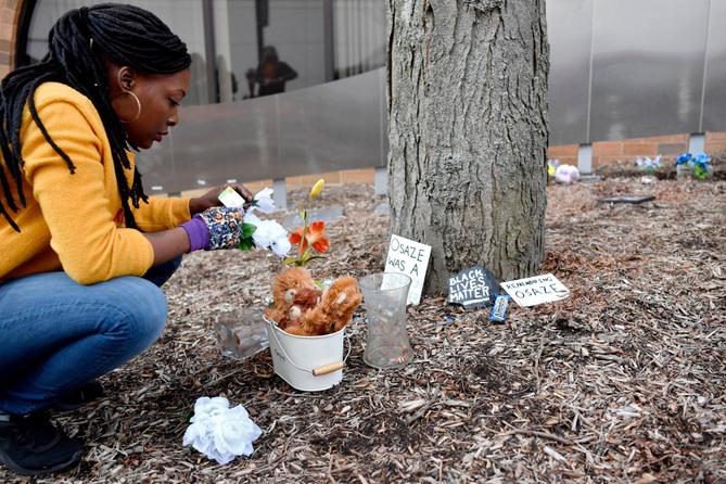 A woman cleans up the Black Lives Matter memorial at the Dr. Martin Luther King Jr. Plaza in downtown State College.