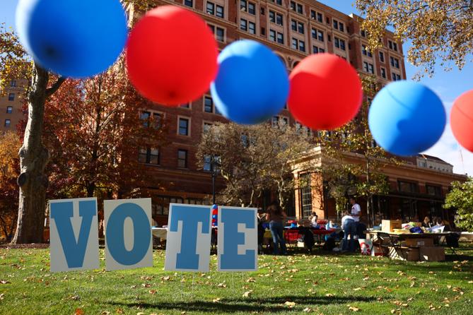 Students on the campus of the University of Pittsburgh walk past a ‘vote’ sign on Election Day, Nov. 5., 2024.