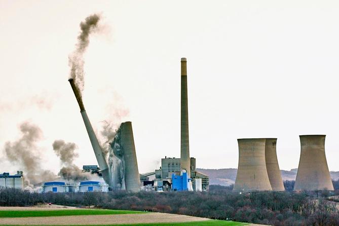 The smokestacks of the former coal-fired Homer City Generating Station crumble in a planned demolition to make way for a new natural gas-fired power plant.